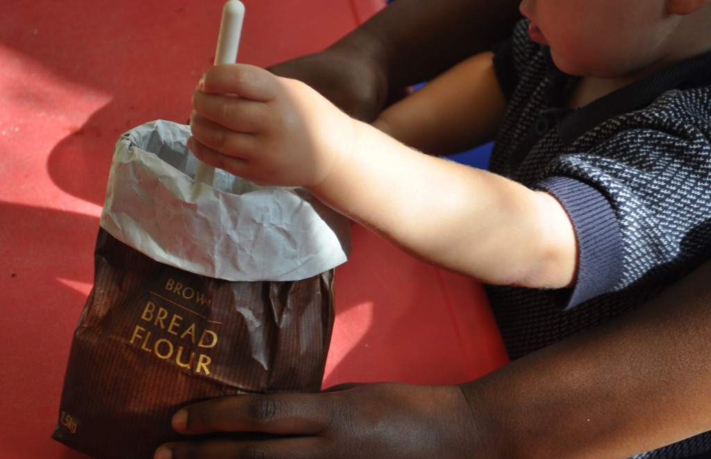 Early Years practitioners supporting children to make bread